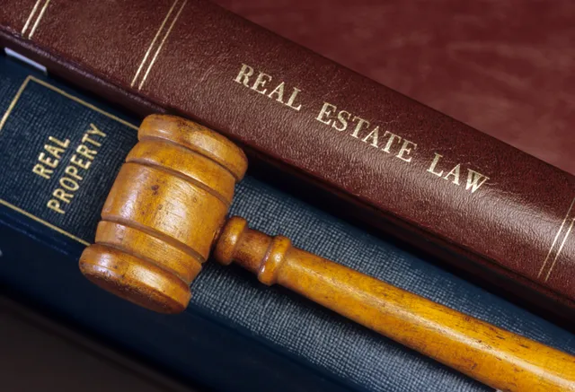 A wooden gavel sitting on top of some books.