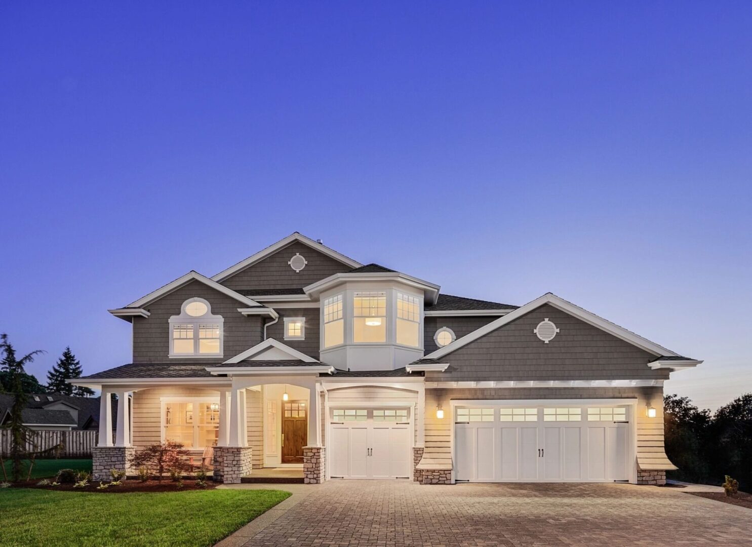 A large house with two garage doors and a driveway.